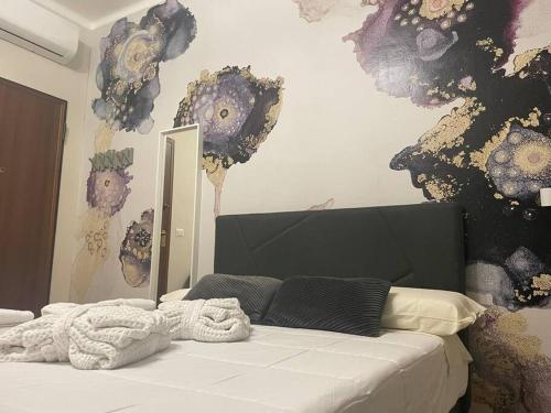 a bedroom with a white bed with flowers on the wall at Cucchiari Suite 7A in Modena