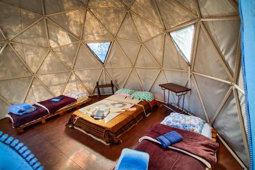 a room with three beds in a yurt at Pousada Ninho da Gralha in Turvo