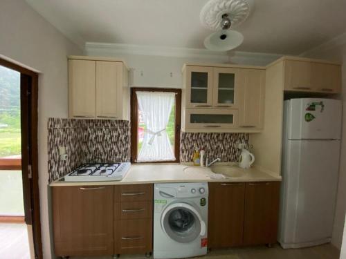 a kitchen with a refrigerator and a washing machine at Talipoğlu Apart in Uzungol