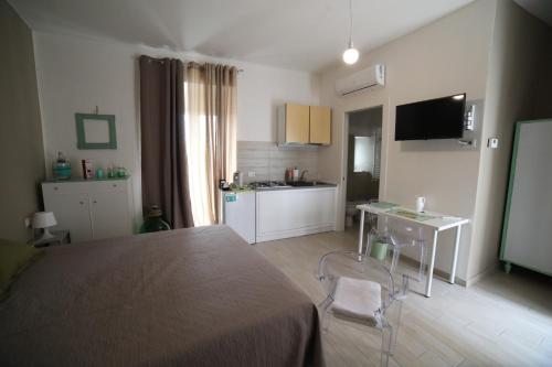 a bedroom with a bed and a table and a kitchen at "Le Dimore degli Artisti" RIPACANDIDA in Ripacandida