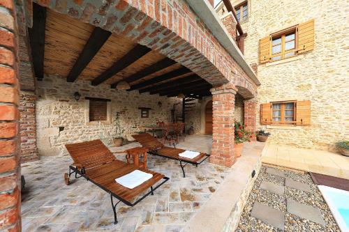 an outdoor patio with wooden chairs and a brick building at Villa Gland in Nin