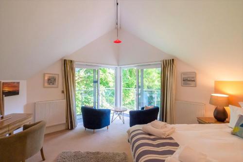 a bedroom with a bed and a table and chairs at Trewhiddle Retreat V11 by Together Travel - Luxury 4-Bedroom Villa in St Austell