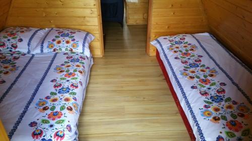 two beds sitting next to each other in a room at LESNA CHATA in Zagórnik