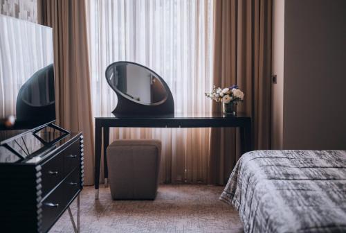 a bedroom with a mirror on a desk next to a bed at Boutique Garni Hotel Townhouse 27 in Belgrade