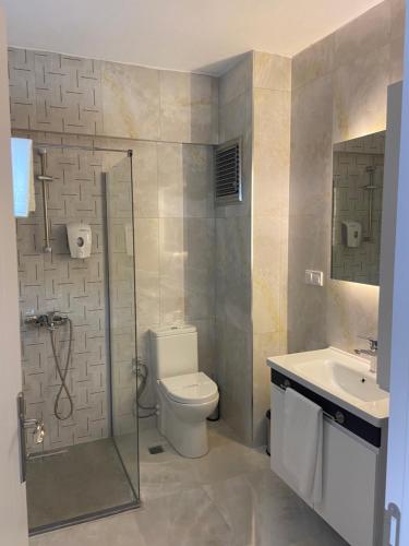 a bathroom with a shower and a toilet and a sink at JK Business in Denizli