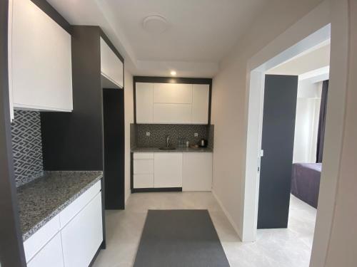 a kitchen with white cabinets and a sink at JK BUSINESS HOTEL in Denizli