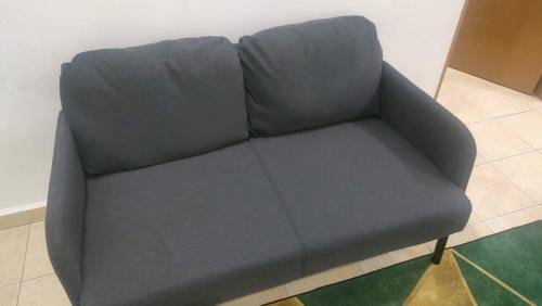 a gray couch sitting in a room with a floor at Deena's Cottage Kulim Hitech Hospital Kulim, Three-bedrooms Single Storey Terrace House in Kulim