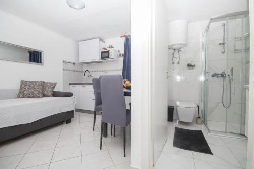 Cette petite chambre comprend un lit et une salle de bains pourvue d'une douche. dans l'établissement Dusica apartments, à Tribunj