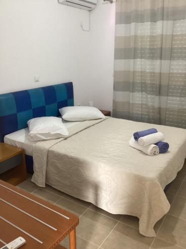 two beds in a hotel room with towels on them at MARMARI apartments in Ayía Marína