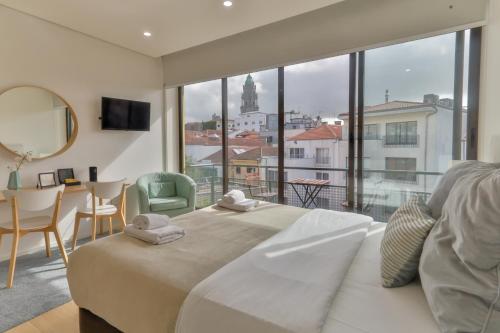 ein Schlafzimmer mit einem großen Bett und einem großen Fenster in der Unterkunft Porto Downtown Living - Picaria Apartments in Porto