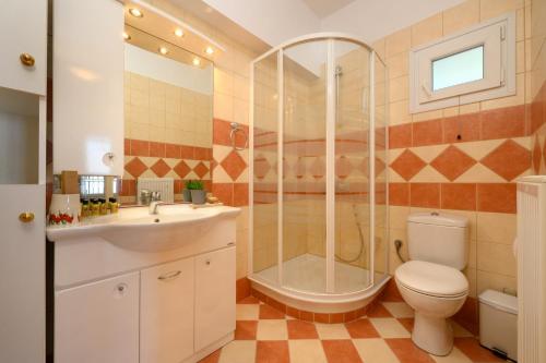 Nisos Sunset Apartments Agios Gordios في مدينة كورفو: حمام مع دش ومرحاض ومغسلة