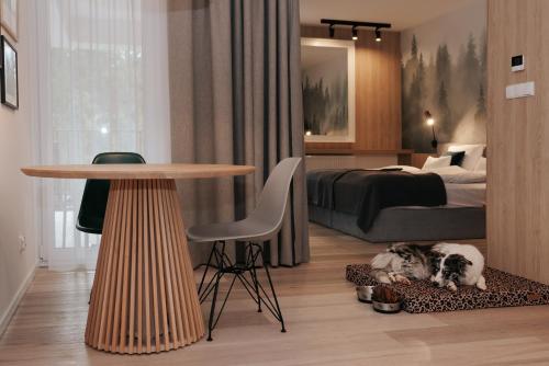 a bedroom with a bed and a table and two dogs at VISLOW Resort in Wisła