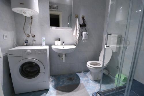 y baño con lavadora y lavamanos. en Flat 23, en Belgrado