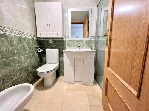 a bathroom with a toilet and a sink and a mirror at Gemelos 22-3-19 in Benidorm