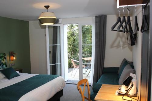 a hotel room with a bed and a table and a patio at Clos De La Vaupalière - Rouen in La Vaupalière
