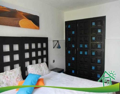 Playa del AguilaにあるBonito apartamento con vista al marのベッドルーム1室(ベッド1台、黒いドア付)