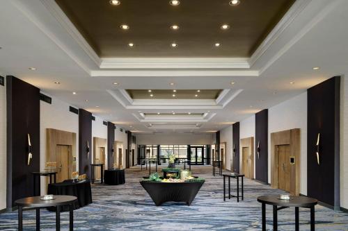 a lobby of a hotel with tables and chairs at Sheraton Grand Rapids Airport Hotel in Grand Rapids