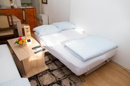 a small bedroom with a bed and a table at Apartman Irina Trebinje in Trebinje