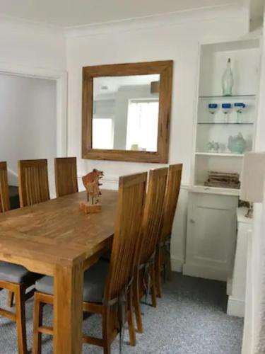 a dining room with a wooden table and chairs at Triple Deck Cottage - 2mins from Mevagissey Harbour in Mevagissey