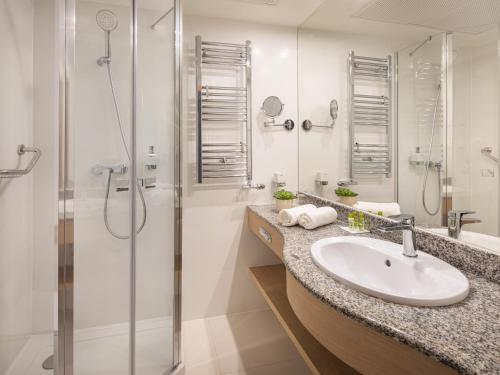 a bathroom with a sink and a shower at Hotel Carbona Thermal Spa in Hévíz
