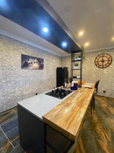 cocina con encimera de madera y reloj en Fenix loft spa, en Ardeşen