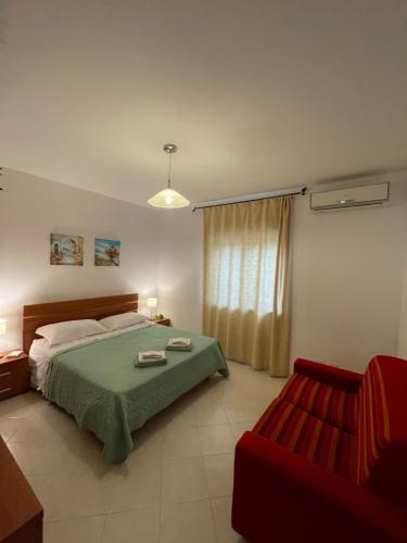 1 dormitorio con 1 cama y 1 silla roja en Appartamento Pizzo Beach, en Pizzo