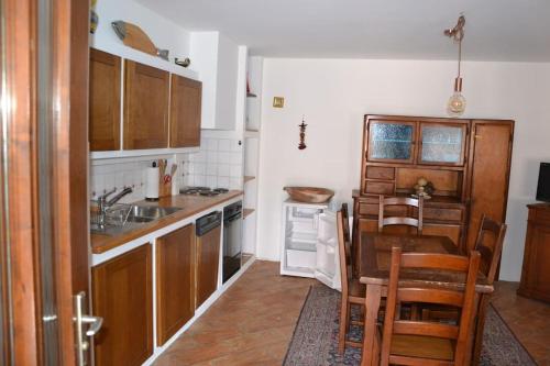 une cuisine avec des placards en bois et une table ainsi qu'une salle à manger dans l'établissement Casa tipica a Meride Al Punt da Gian, à Meride
