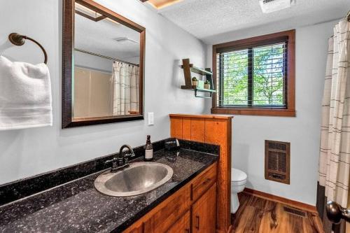 a bathroom with a sink and a mirror at Sleeps 8! Fire Pit, Games, 15 Mins from Downtown Blue Ridge in Mineral Bluff