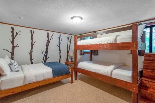 two bunk beds in a room with trees on the wall at Sleeps 8! Fire Pit, Games, 15 Mins from Downtown Blue Ridge in Mineral Bluff