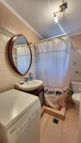 a bathroom with a sink and a toilet and a mirror at Evita Maisonette, Elegant Beachfront apt, Polychrono in Polykhrono