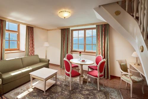 a living room with a couch and a table and chairs at Grand Hotel Zell am See in Zell am See