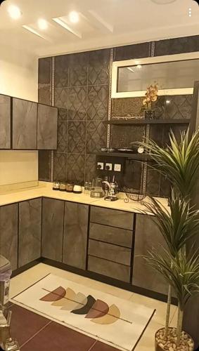 a kitchen with a counter and a table and a plant at Classy Apartment in Buraydah