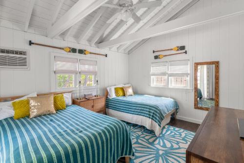 1 dormitorio con 2 camas, mesa y ventanas en 15 Seneca, en Ocean Bay Park