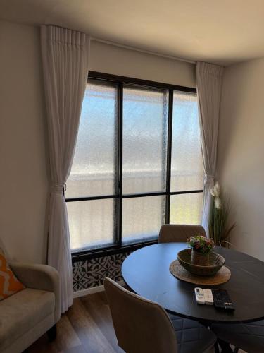 a living room with a table and a large window at דירת בוטיק Dnine7 in Haifa