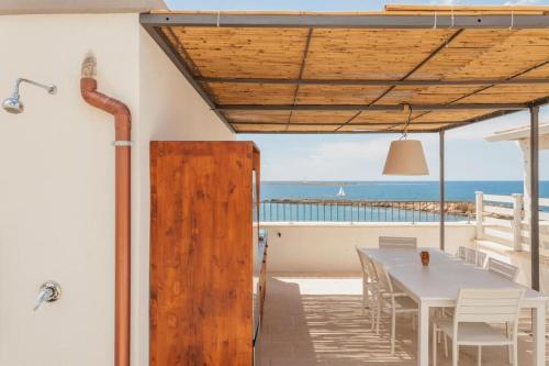 una sala da pranzo con tavolo e vista sull'oceano di Dimora San Felice Il Fico a Gallipoli