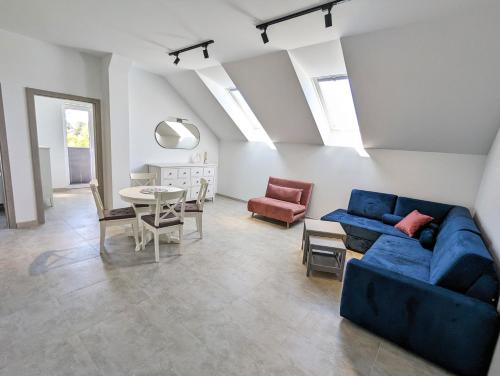 - un salon avec un canapé bleu et une table dans l'établissement Apartamenty Sarbinowo Mirror Reflection, à Sarbinowo
