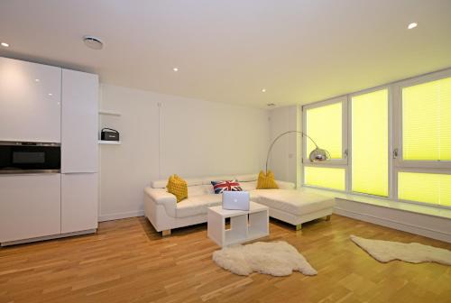 a living room with a couch and a table at Kew Bridge Penthouse in London