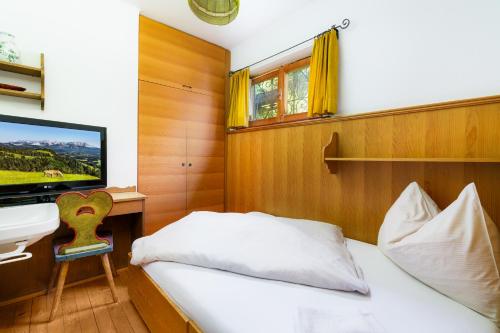a bedroom with a bed and a desk and a tv at Chalet Levi by Alpine Host Helpers in Kirchberg in Tirol