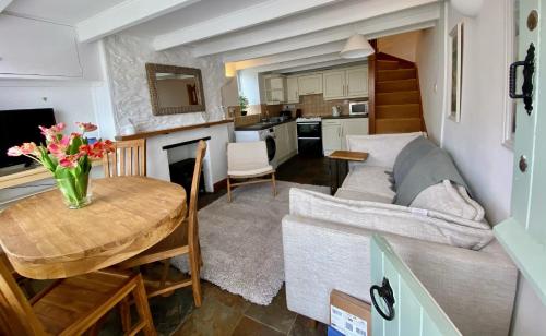 een keuken en een woonkamer met een tafel en een bank bij The Little Lighthouse - 2 minutes from the beach in Pentewan