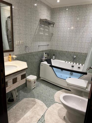 ein Badezimmer mit einer Badewanne, einem WC und einem Waschbecken in der Unterkunft شاليه La veranda in Durrat Al-Arus