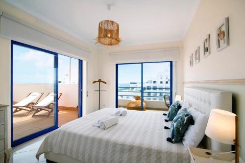 a bedroom with a large bed and a balcony at Pérola do Atlântico By the Sea in Quarteira