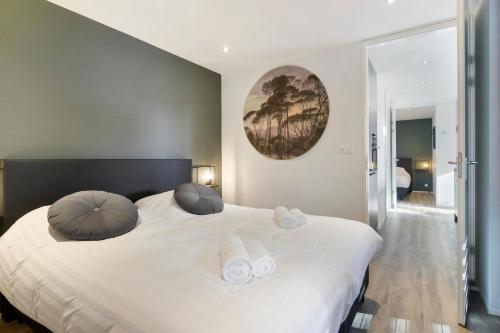 um quarto com uma grande cama branca e 2 almofadas em Soof Heuvelrug em Rhenen