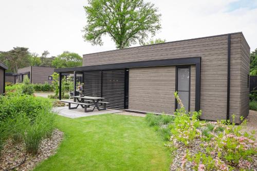 a small house with a picnic table in a garden at Soof Heuvelrug in Rhenen