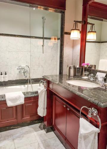 a bathroom with a tub and a sink and a mirror at InterContinental Bordeaux Le Grand Hotel by IHG in Bordeaux