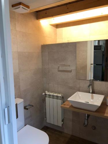 a bathroom with a white sink and a toilet at Apartamentos El Arroyo in Armal