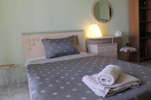 - une chambre avec un lit et une serviette dans l'établissement Comfortable Apartment in the Center of Alexandroupolis, à Alexandroúpolis