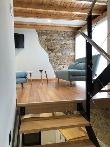 a room with two blue chairs and a table at Apartamentos El Arroyo in Armal