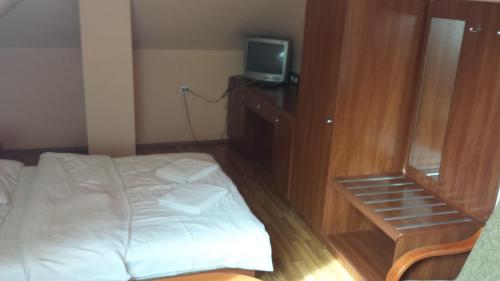 a bedroom with a bed and a tv on a dresser at Zajazd Pasja in Sławków