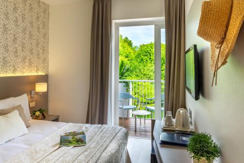 Hotel Renania في بيبيوني: غرفه فندقيه بسرير وشرفه