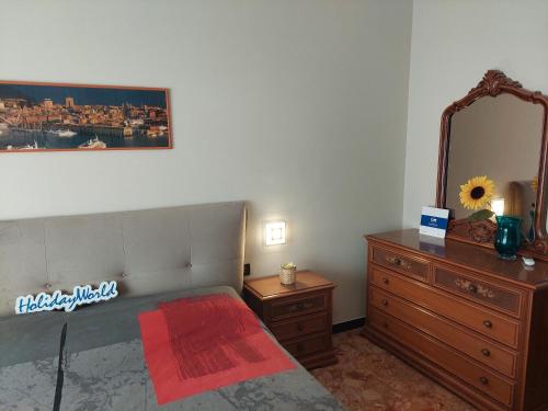 sypialnia z łóżkiem, komodą i lustrem w obiekcie House Mamma Marisa by Holiday World w Genui